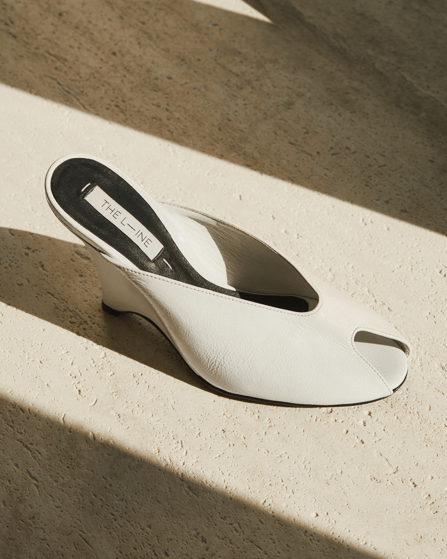White leather peep-toe wedge mule in sunlight